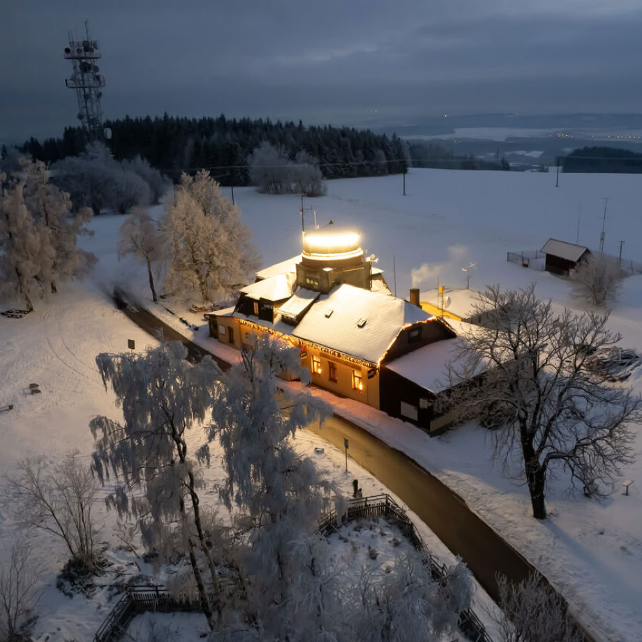 A serene A-frame cabin surrounded by lush greenery under a clear blue sky.
